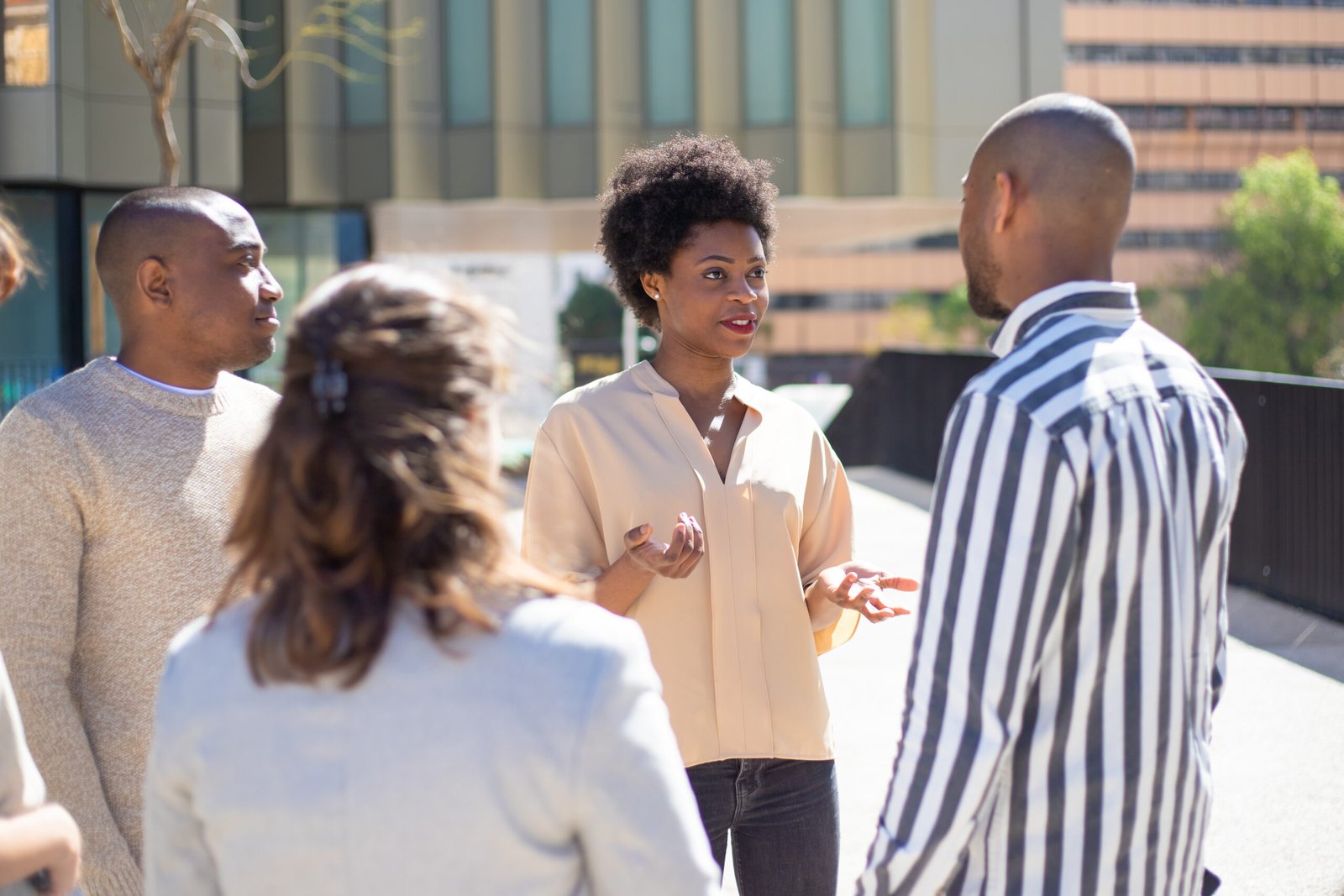 group of young friends standing on street and communicating